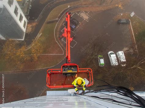 5G network installation, technicians work on a building using the lift ...