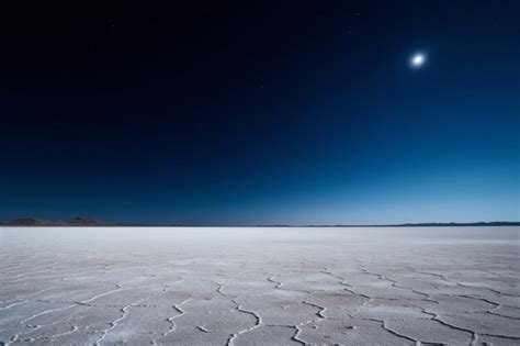 Premium AI Image | a desert with a moon and a blue sky