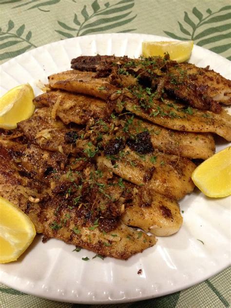 a white plate topped with chicken and lemon slices