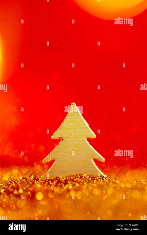 Christmas wallpaper in gold and red colors.Christmas tree in gold glitter on a on a red ...