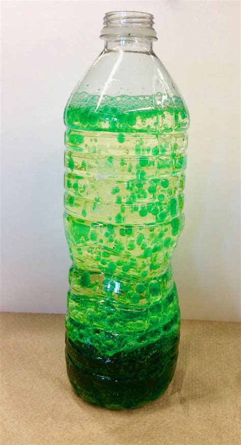 a green and yellow liquid bottle sitting on top of a table