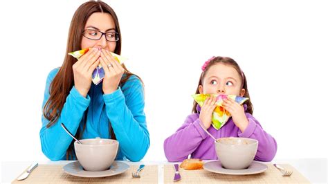 mother teaching daughter table manners