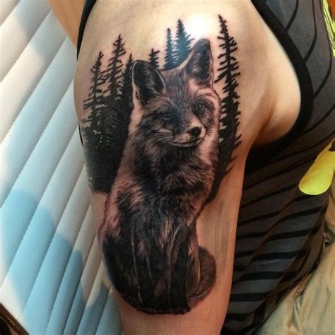 a woman's thigh with a tattoo of a fox and pine trees on it