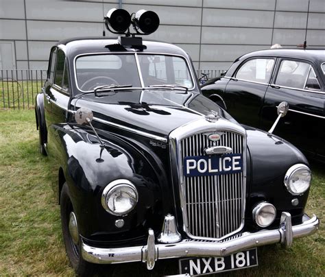 an old police car is parked in the grass