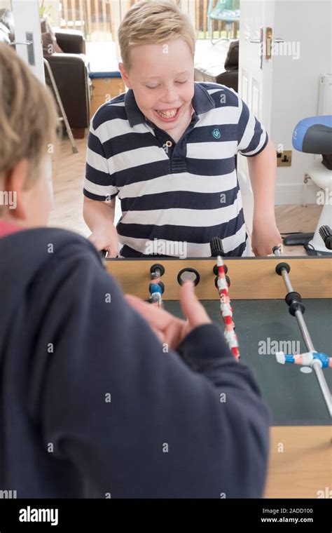 Boy with cerebral palsy. 10-year-old boy with cerebral palsy kneeling on an adjustable stool ...