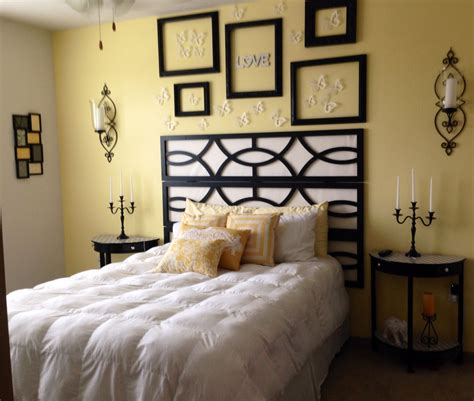 a bedroom with yellow walls and pictures on the wall above the bed, along with candles