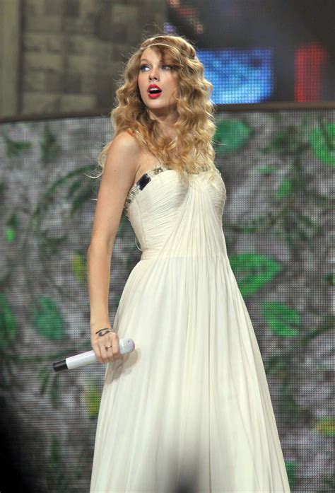 a woman in a white dress holding a microphone