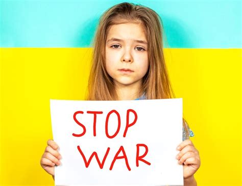 Premium Photo | The girl holds a stop war poster in her hands against the background of the ...