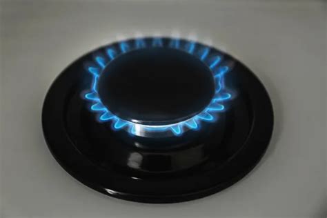 Gas burner with blue flame on modern stove, closeup - Stock Image ...