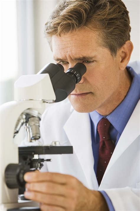 Medical professional looking through a microscope - StockFreedom - Premium Stock Photography