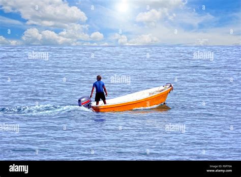 Man on a small boat in the middle of the ocean Stock Photo - Alamy