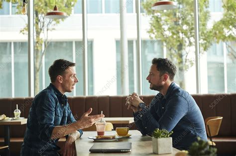 Two men talking in a cafe - Stock Image - F033/4346 - Science Photo Library