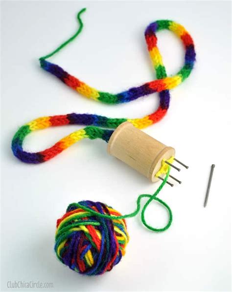 the yarn is being used to make a colorful ball of yarn with a wooden spool