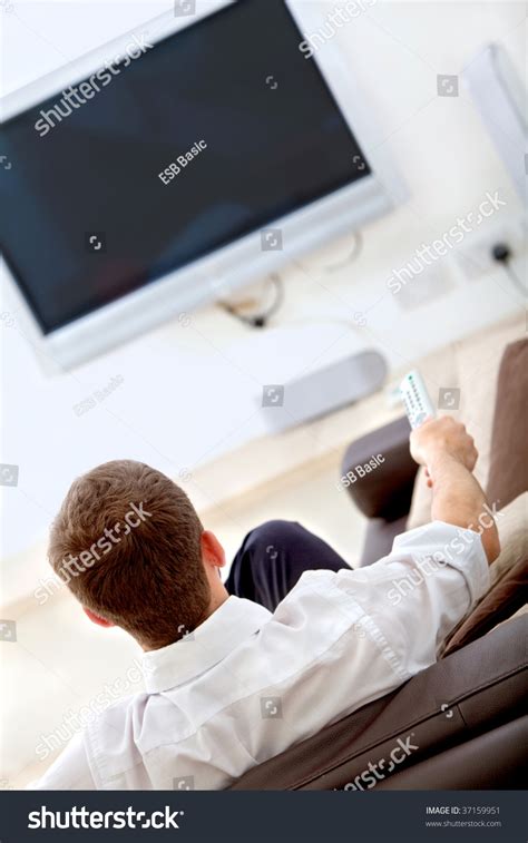 Man Sitting On A Couch Watching Television Stock Photo 37159951 : Shutterstock