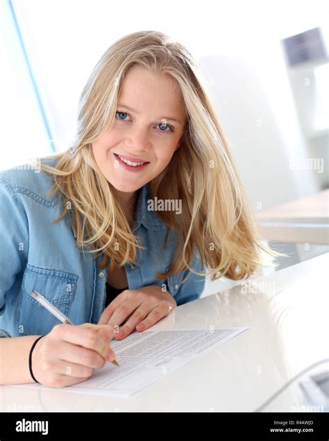 Smiling blond girl filling school application form Stock Photo - Alamy