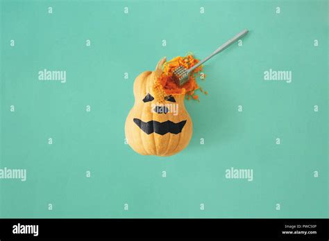 Flat lay funny scary face Halloween pumpkins on turquoise background. Fall autumn halloween ...