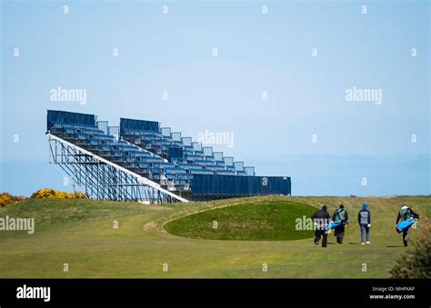 Golfers approach green beside spectator stand under construction at Carnoustie Golf Links in ...