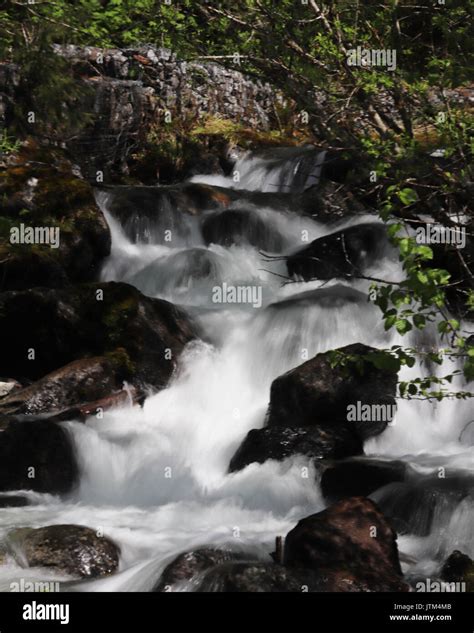 Small waterfall as river runs down mountainside Stock Photo - Alamy