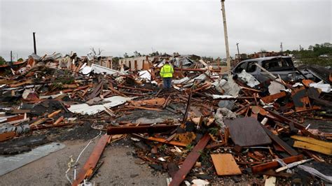 A man is surrounded by tornado damage after severe storms moved through ...