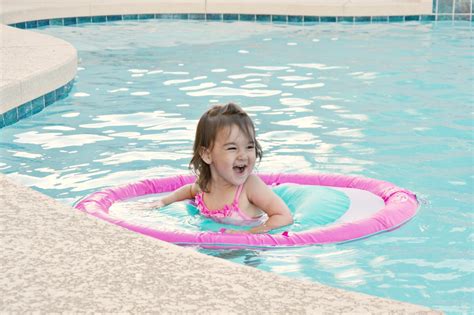 toddler in backyard pool with SwimWays Baby Spring Float - Brie Brie Blooms