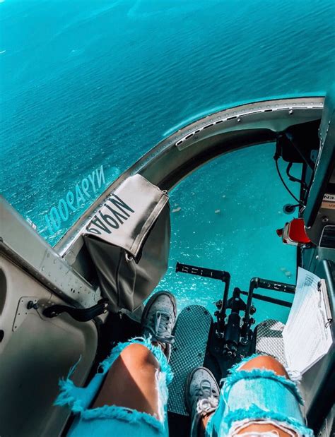 someone is sitting in the cockpit of a plane looking down at the water and land