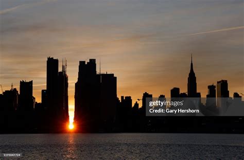 The sun rises during a Manhattanhenge sunrise along 42nd Street... News ...