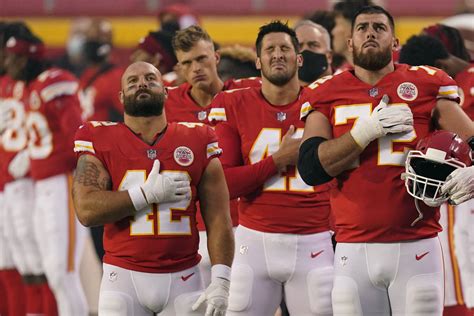 Kansas City Chiefs players stand for the national anthem before an NFL football game against th ...