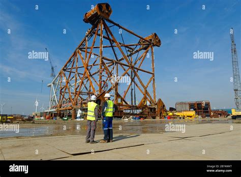 Construction workers in front of an offshore oil and gas platform also ...