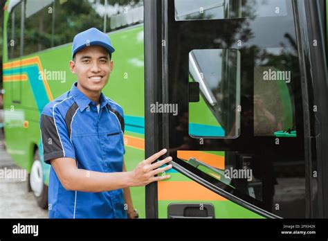 a bus driver in a uniform and a hat opened the bus door Stock Photo - Alamy