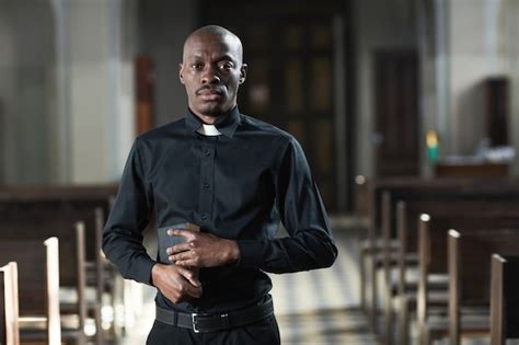 Premium Photo | Portrait of priest standing isolated on black