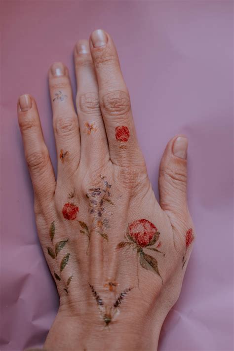 Photo of Flower Tattoos on Person's Left Hand · Free Stock Photo