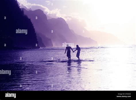 Couple on beach in Hawaii sunset Stock Photo - Alamy