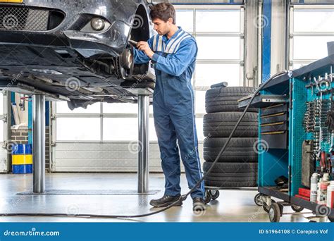 Mechanic Repairing Car on Hydraulic Lift Stock Photo - Image of ...