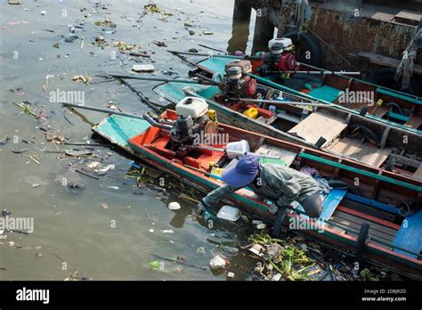 Taxi boats on Chao Phraya river in Bangkok, Thailand. A woman picks the ...