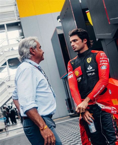 two men standing next to each other in front of a building