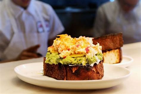 two white plates topped with toast and guacamole