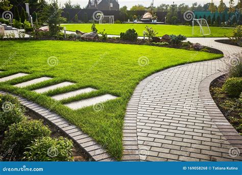 Landscaping of the Garden. Path Curving through Lawn with Green Grass and Walkway Tiles. Stock ...