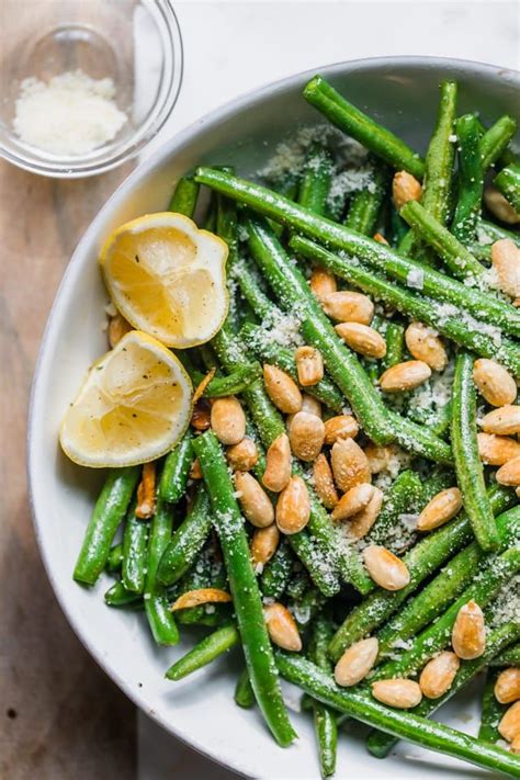 a white bowl filled with green beans and almonds