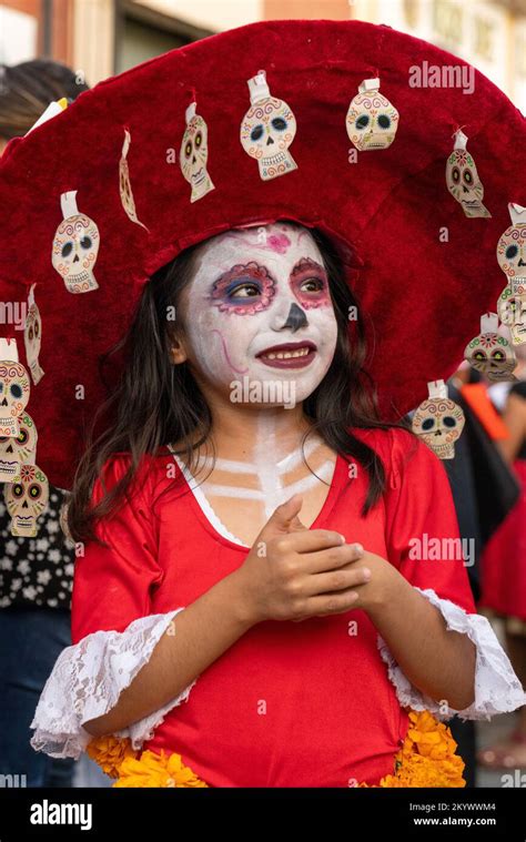 A young girl in costume as La Catrina with face paint for a Day of the Dead children's parade on ...