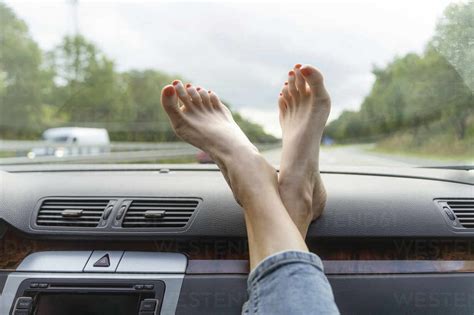 Mature woman with feet up on car dashboard stock photo