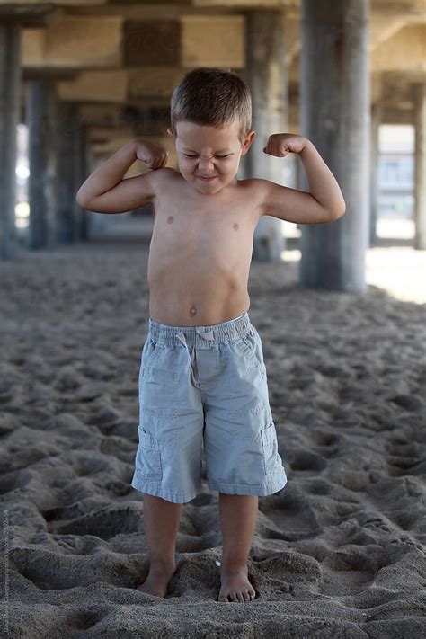 "Little Boy Flexing His Muscles On The Beach" by Stocksy Contributor "Dina Marie Giangregorio ...