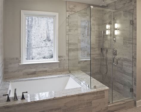 Bathroom remodel by Craftworks Contruction. Glass enclosed shower, drop in tub surrounded by ...