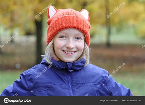 Cheerful girl smiling in a funny hat knitted. Autumn. Stock Photo by ©milkakotka 128070584