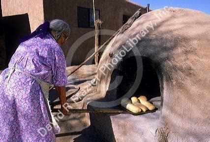 Indian pueblo woman uses an outdoor oven for baking bread in Taos, New ...