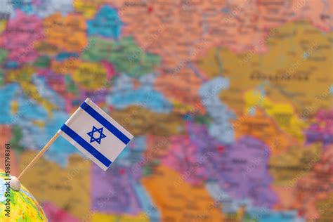 The flag of Israel on the background of a blurry map is out of focus ...