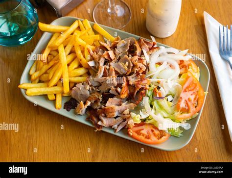 Dish Doner kebab with French fries and a light vegetable salad Stock ...