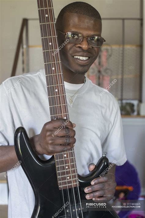 Young man with Williams Syndrome playing his electric guitar — eyeglasses, happiness - Stock ...