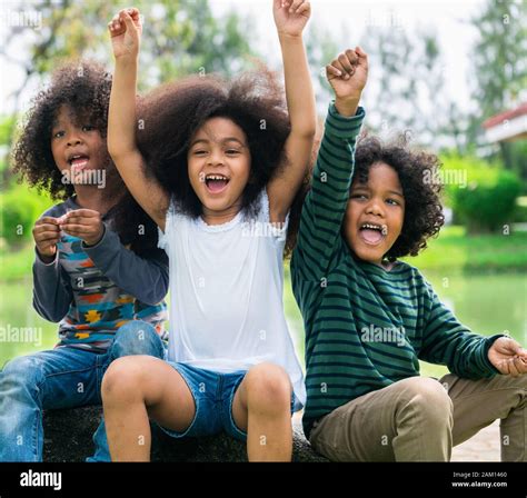 Happy African American boy and girl kids group playing in the playground in school. Children ...