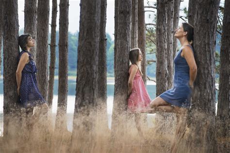 A group of people communing with nature, and leaning against tall ...