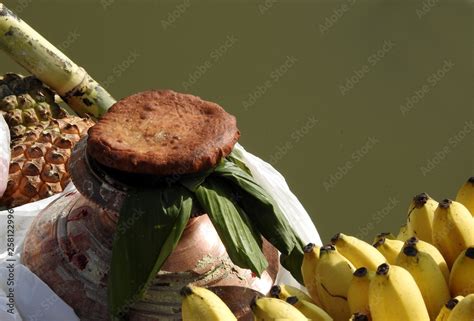 Food offerings by Hindu woman to pray sun God, at dusk,in the bank of lake, during annual ritual ...